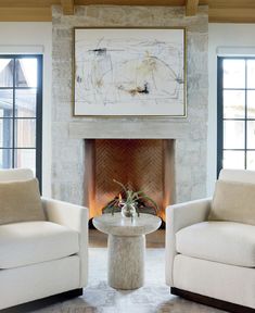 a living room filled with furniture and a fire place in front of a painting on the wall