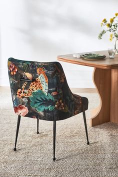 a chair that is sitting in front of a table with flowers and plates on it