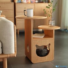 a cat house with a coffee cup on the table next to it and a couch in the background