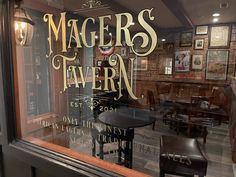 there is a sign that says magers tavern on the window in front of it