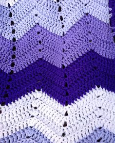 a crocheted purple and white blanket with black dots