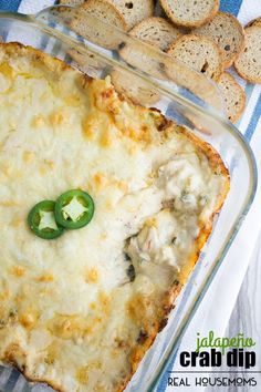 a cheesy casserole with green peppers and crackers on the side