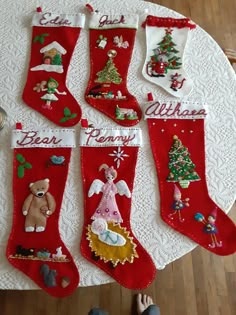 christmas stockings with teddy bears and other holiday decorations on a white doily covered table