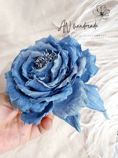 a person holding a blue flower in their hand