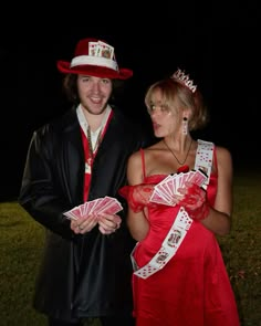 two people dressed up in costumes and holding cards