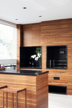 a kitchen with wooden cabinets and black counter tops, along with two bar stools