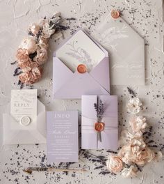 the wedding stationery is laid out with flowers