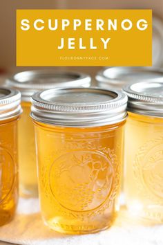 four jars filled with yellow liquid sitting on top of a table