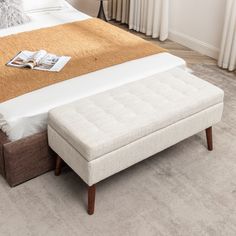 a bed with a footstool sitting on top of it