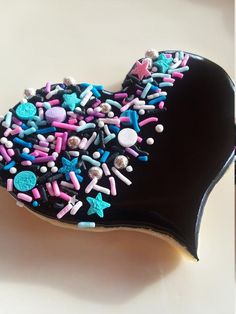 a heart shaped cookie with sprinkles and stars