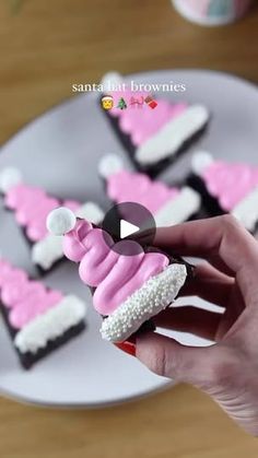 someone is holding up some pink and white decorated cookies