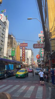 a busy city street filled with lots of traffic and people standing on the side of it