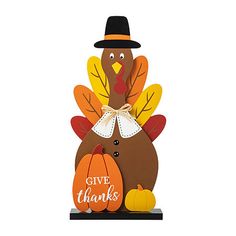 a wooden turkey with a black hat on it's head and some pumpkins