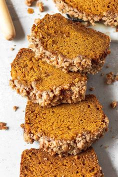 four slices of pumpkin bread stacked on top of each other next to a wooden spoon