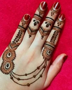 a woman's hand with henna tattoos on it and two rings around her fingers