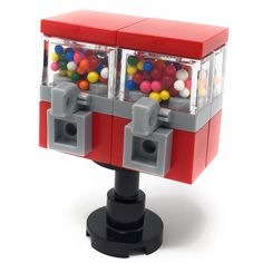 a red and gray toy machine with gumballs in it