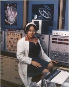 a woman sitting in front of some electronic equipment