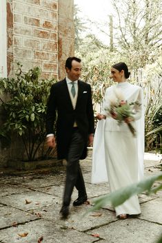 a bride and groom walking down the street