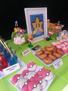 a green table topped with lots of desserts and candy bar items on top of it