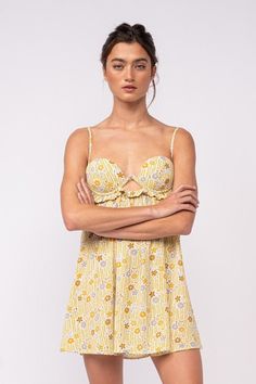 The Drew Olive Floral Babydoll Cami Mini Dress is here for sunshine and fun summer days! Olive, mustard yellow, ivory, and blue floral fabric form this cute floral bralette babydoll dress with cami straps and a bralette cutout bodice. The attached mini skirt falls from an empire waist. A ruffle back with ties finishes the look! Style with cute sandals for a fun summer look! DETAILS & CARE 100% Polyester. 100% Polyester Lining. Machine wash cold. Imported. ORDERS, SHIPPING & RETURNS Orders, Shipp Spring Cotton Dress With Built-in Bra, Spring Strapless Sundress With Adjustable Straps, Spring Sundress With Spaghetti Straps And Built-in Bra, Feminine Summer Sundress With Sweetheart Neckline, Flirty Summer Sundress With Adjustable Straps, Strapless Sundress With Adjustable Straps For Spring, Spring Brunch Dresses With Built-in Bra, Flirty Sundress With Sweetheart Neckline For Summer, Spring Beachwear Sundress With Spaghetti Straps