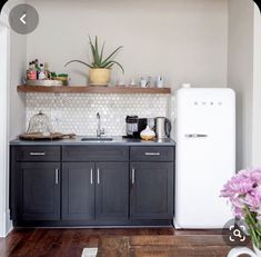 a kitchen with black cabinets and white appliances