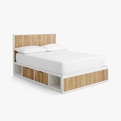 a white bed with wooden headboard and drawers on the bottom shelf in front of it