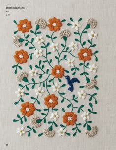 an embroidered piece with flowers and a bird on the side, in orange and white colors