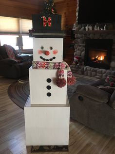 a snowman made out of wood sitting on top of a wooden floor next to a fire place