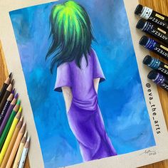 a drawing of a girl with green hair and blue dress is next to colored crayons