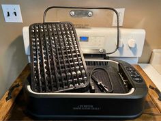 an electric grill on top of a wooden table