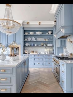 a kitchen with blue cabinets and white counter tops, gold trimmings on the shelves