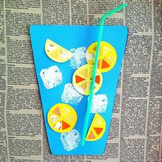 a blue book with yellow and orange paper cutouts on it next to a green straw