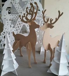 two paper deer standing next to each other