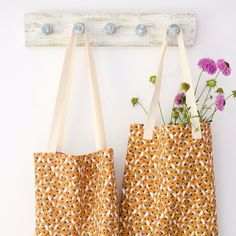 two bags with flowers in them hanging on a wall