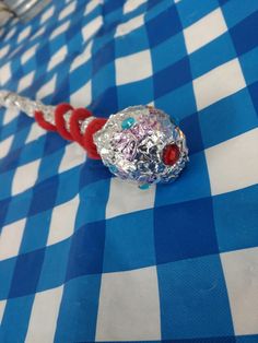 a candy bar wrapped in tin foil on a blue and white checkered tablecloth