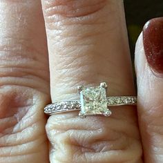 a woman's hand with a diamond ring on top of her finger and an engagement band