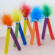 four colorful toothbrushes with googly eyes and long sticks sticking out of them