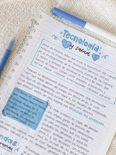 a notebook with writing on it next to a blue pen and paper clippings