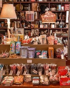 a store filled with lots of different types of candy and candies on wooden shelves