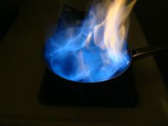 a blue flame in a black pot on a stove