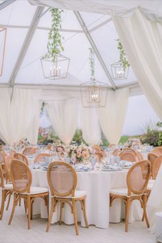 the tables are set with white linens and floral centerpieces for an elegant wedding reception