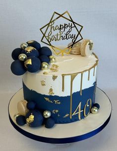 a blue and white birthday cake with gold decorations