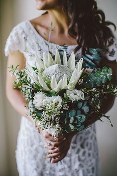 a woman holding a bouquet of flowers in her hands