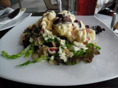 a white plate topped with salad covered in dressing