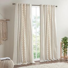 a living room with white curtains and rugs