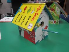 a birdhouse that is sitting on top of a table with a book about dr seuss