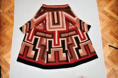 a brown and black dress sitting on top of a wooden floor