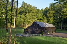 a barn sits in the middle of a wooded area