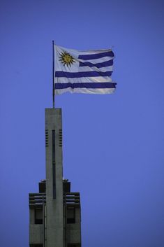 an image of a flag flying from the top of a tall building in the sky