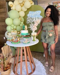 a woman standing in front of a cake table